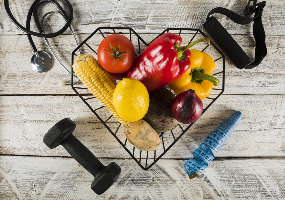 verduras-frescas-rodeadas-de-equipos-de-fitness-estetoscopio-y-cinta-metrica