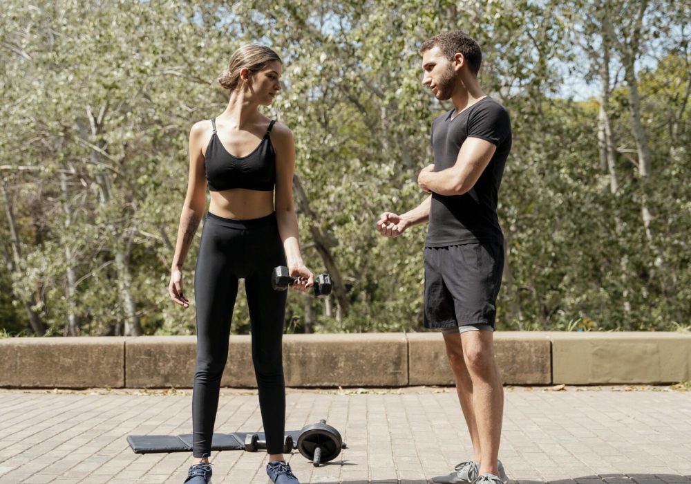 vista-frontal-del-hombre-y-la-mujer-al-aire-libre-juntos-preparandose-para-hacer-ejercicio
