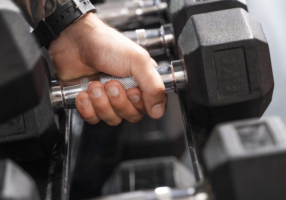 vista-lateral-mano-sosteniendo-mancuerna